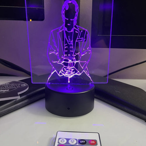 An engraved acrylic panel lit purple on a color-changing LED base with its remote