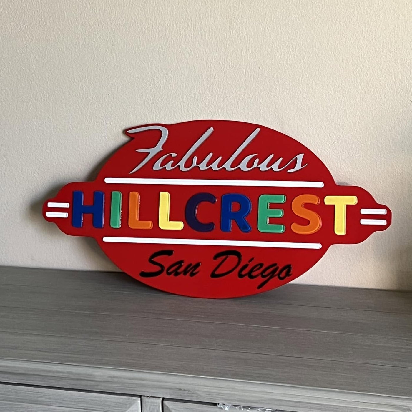 A layered wood sign reading Fabulous Hillcrest San Diego in red with multicolored letters